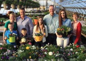 Group Photo with Family in a Greenhouse holding plants