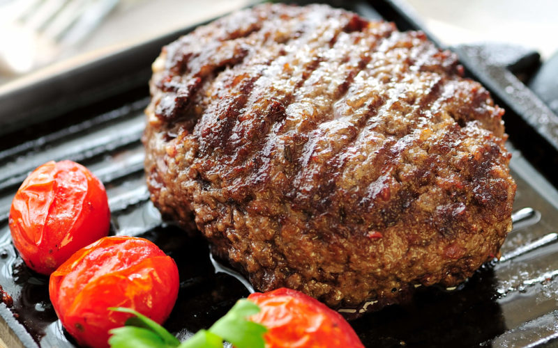 burger with tomatoes on the grill