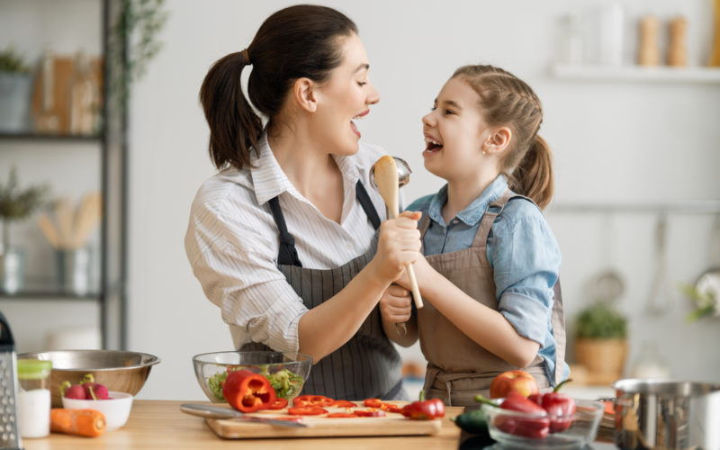 Mom and daughter cooking in the kitchen together.