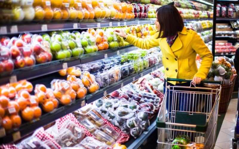 Woman in produce aisle at grocery store.